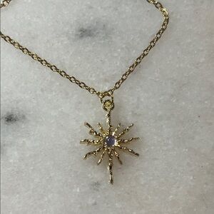 Radiant Gold Starburst Necklace with Purple Accent